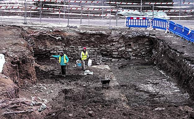 Los restos del supuesto muro del convento de San Francisco, a la espalda de los arqueólogos, y los vestigios de otro edificio, delante de estos expertos. 