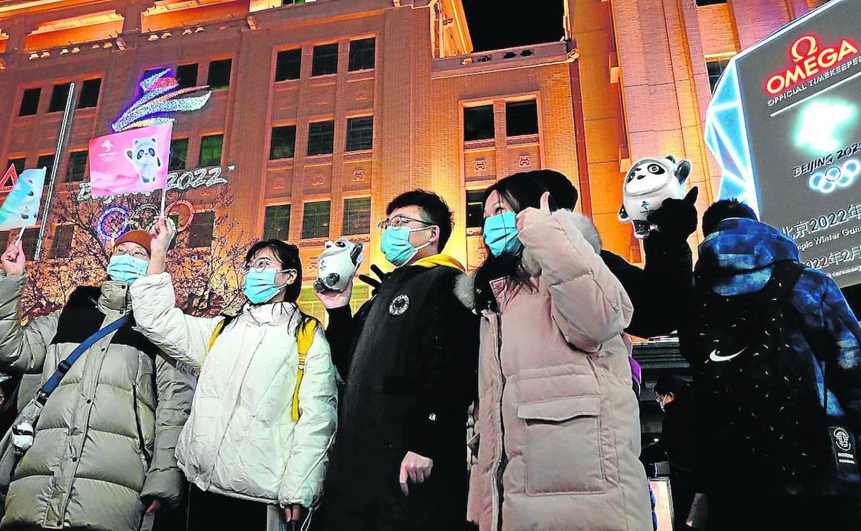 Cuenta atrás. Varios jóvenes chinos, con mascotas y otros elementos vinculados con los Juegos de Pekín. 