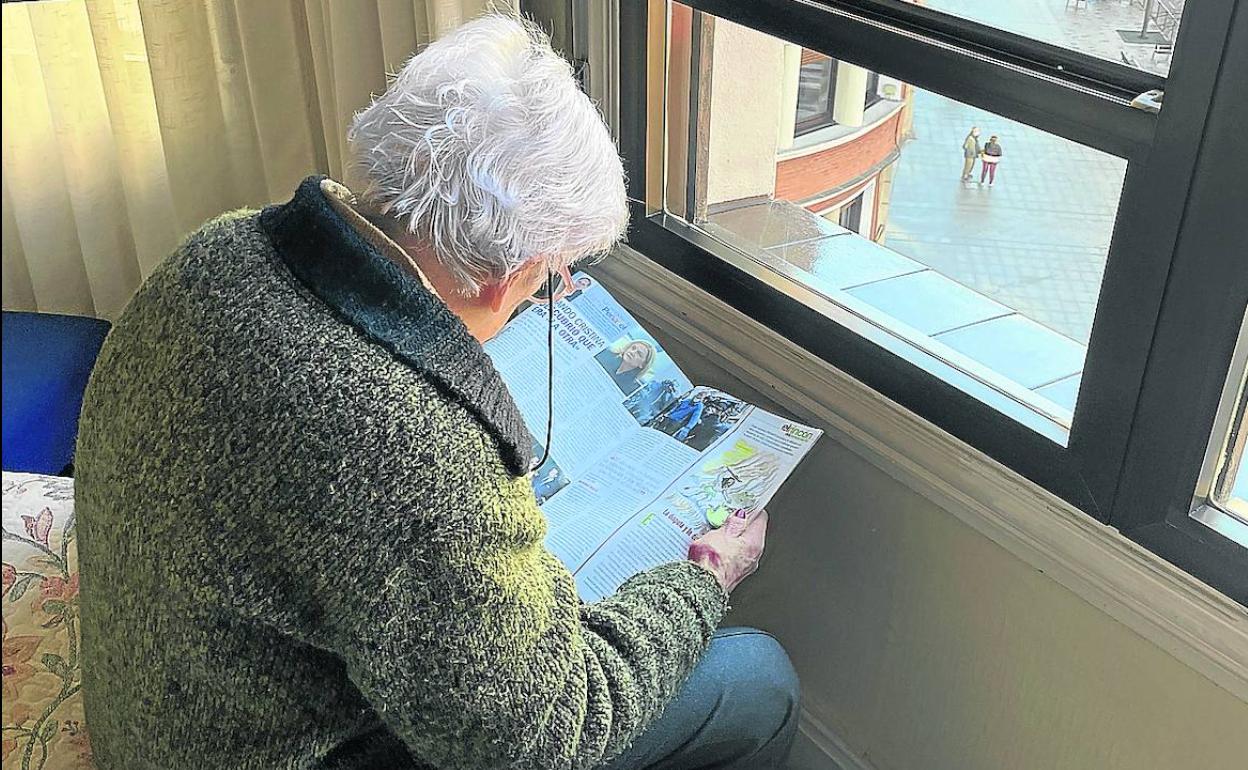 Pilar lee una revista en su dormitorio. 