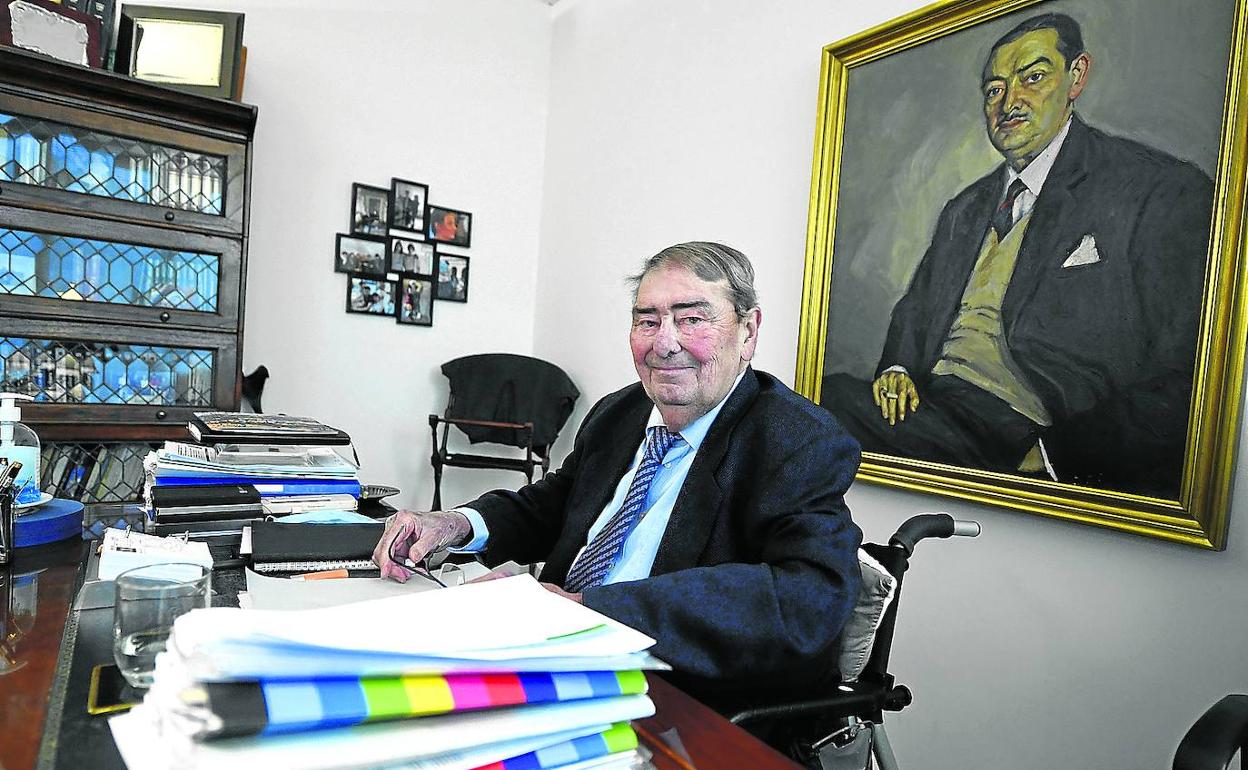 Alejandro Echevarría posa en su despacho junto a un retrato de su padre. 