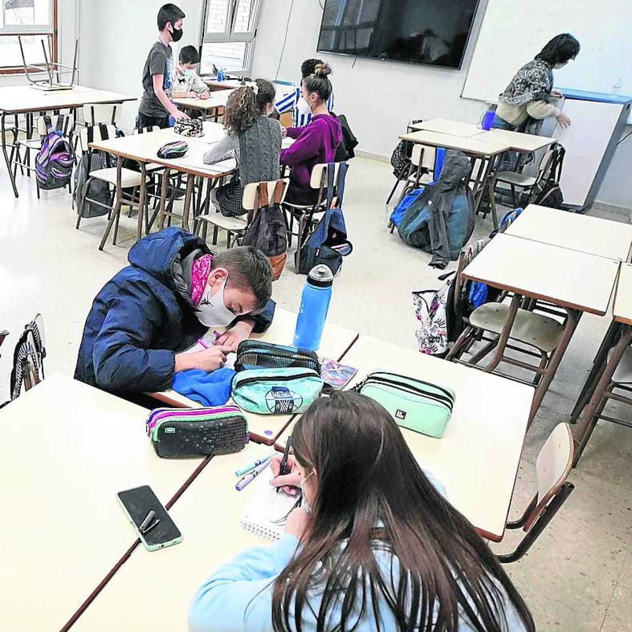 Alumnos atienden a sus tareas en un aula. 