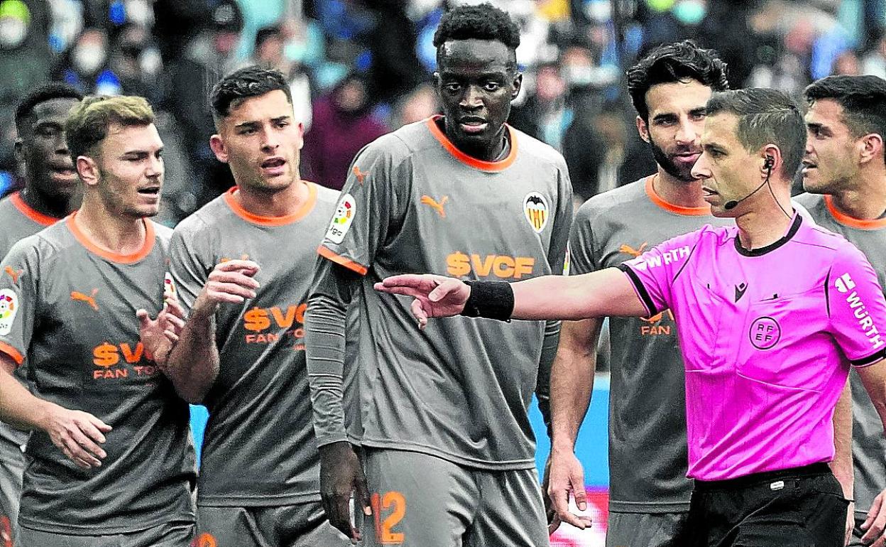 Jugadores del Valencia protestan a Cordero Vega el penalti señalado a favor del Alavés. 