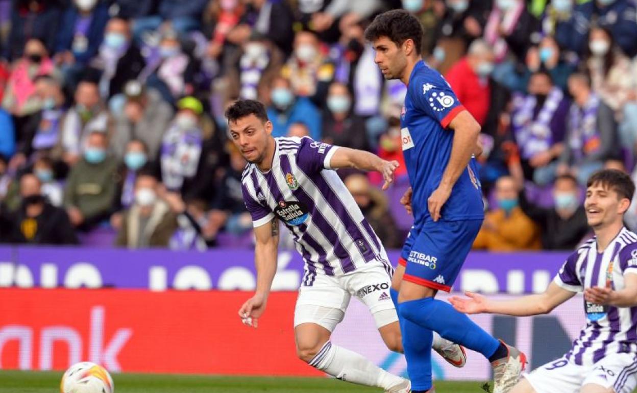 Óscar Gil saca el balón ante dos jugadores del Valladolid. 