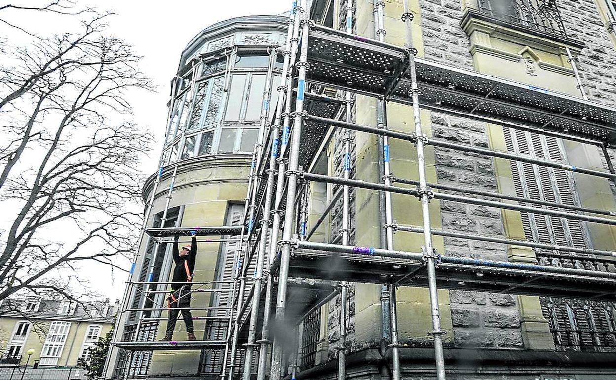 Un operario coloca los andamios de obra en el exterior del palacete de La Senda, que se somete a importantes reformas.