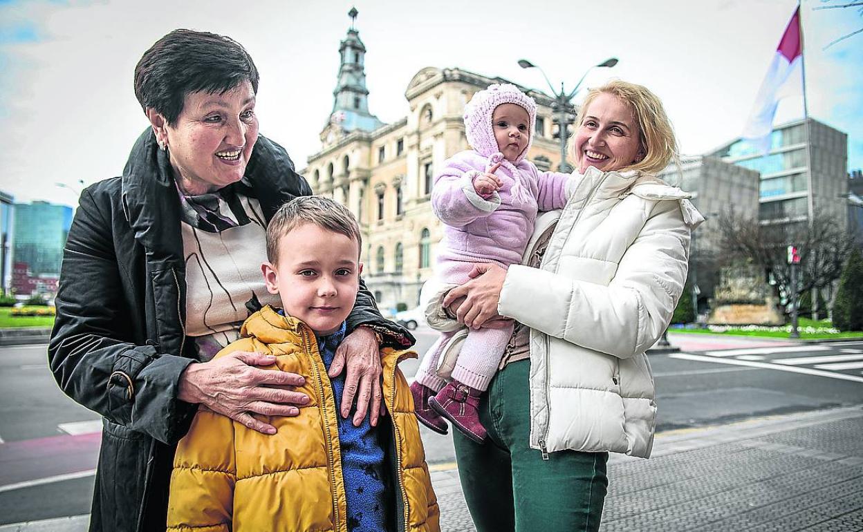 Los pequeños Maksym y Marta, con su abuela y su madre, frente al Ayuntamiento de Bilbao. 