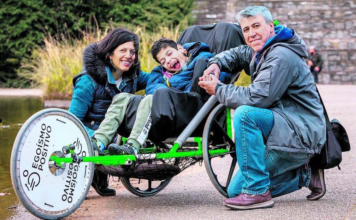 Gianluca correrá el Maratón Martín Fiz subido a este prototipo. Posa sonriente con su madre Patricia y su vecino Txema. 