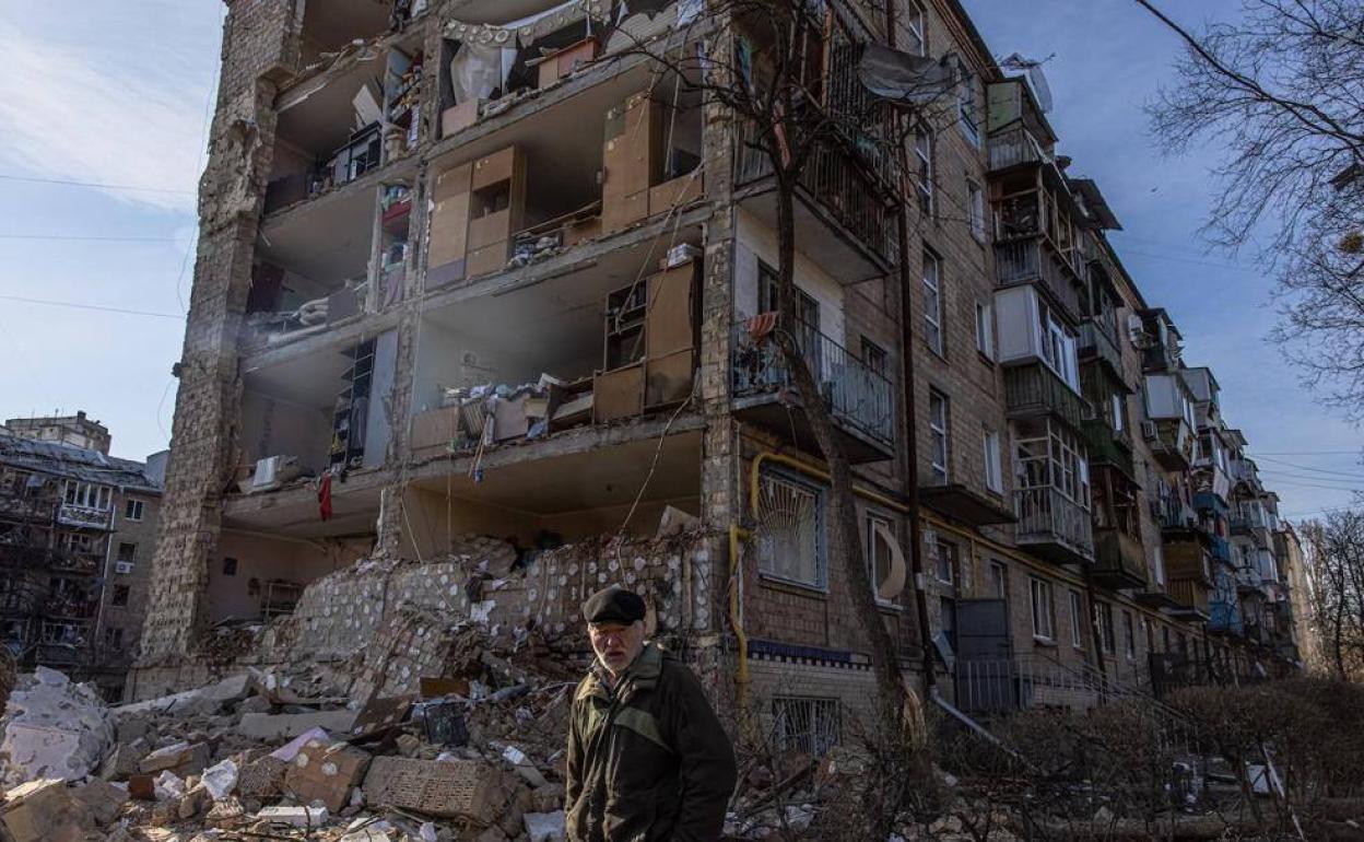 Un hombre camina delante de un edificio de viviendas bombardeado en el distrito de Podilskyi en Kiev. 