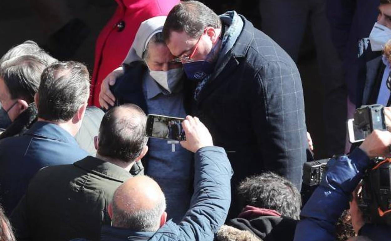 El presidente del Principado, Adrián Barbón, abraza a una religiosa mientras participa junto a decenas de vecinos de Oviedo.