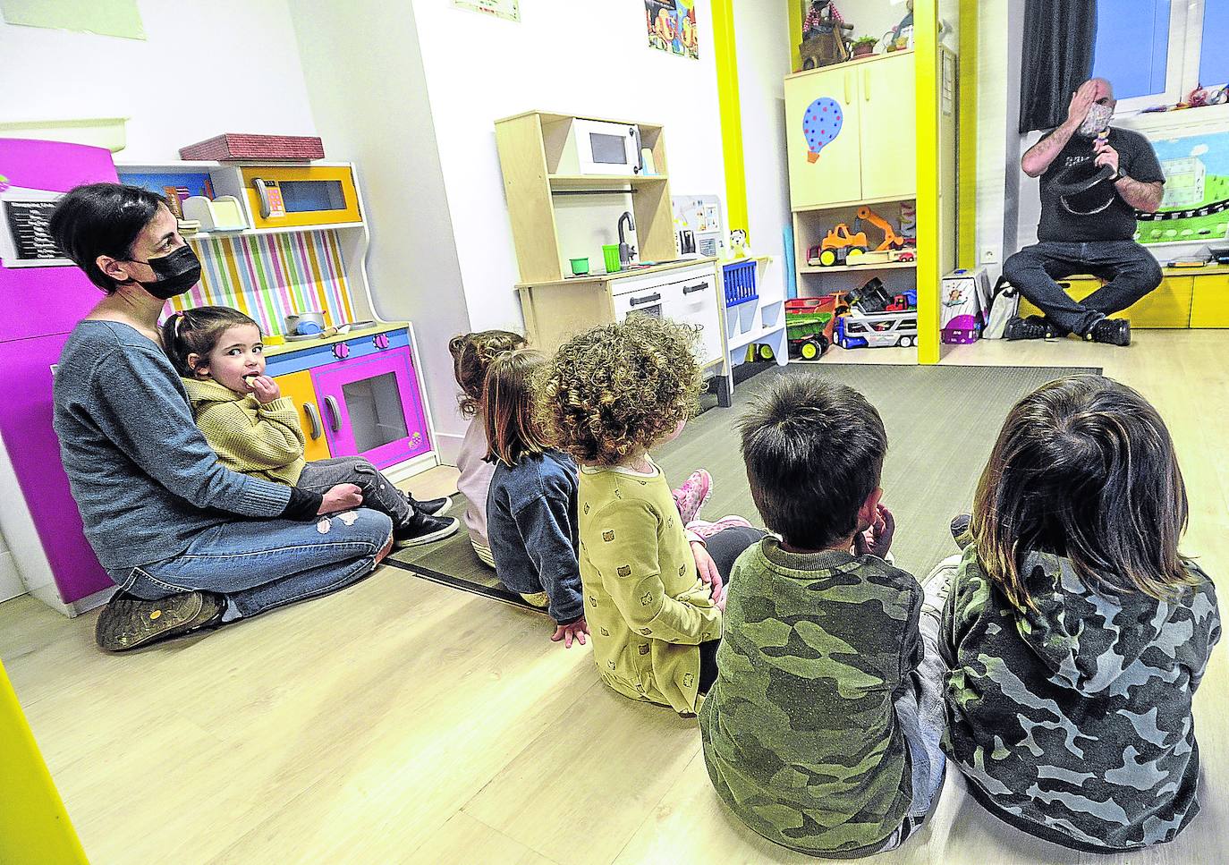 La pequeña Yeva, que mira a cámara en el regazo de su madre, atiende a la clase, en euskera, del maisu Gustavo en Urkide.