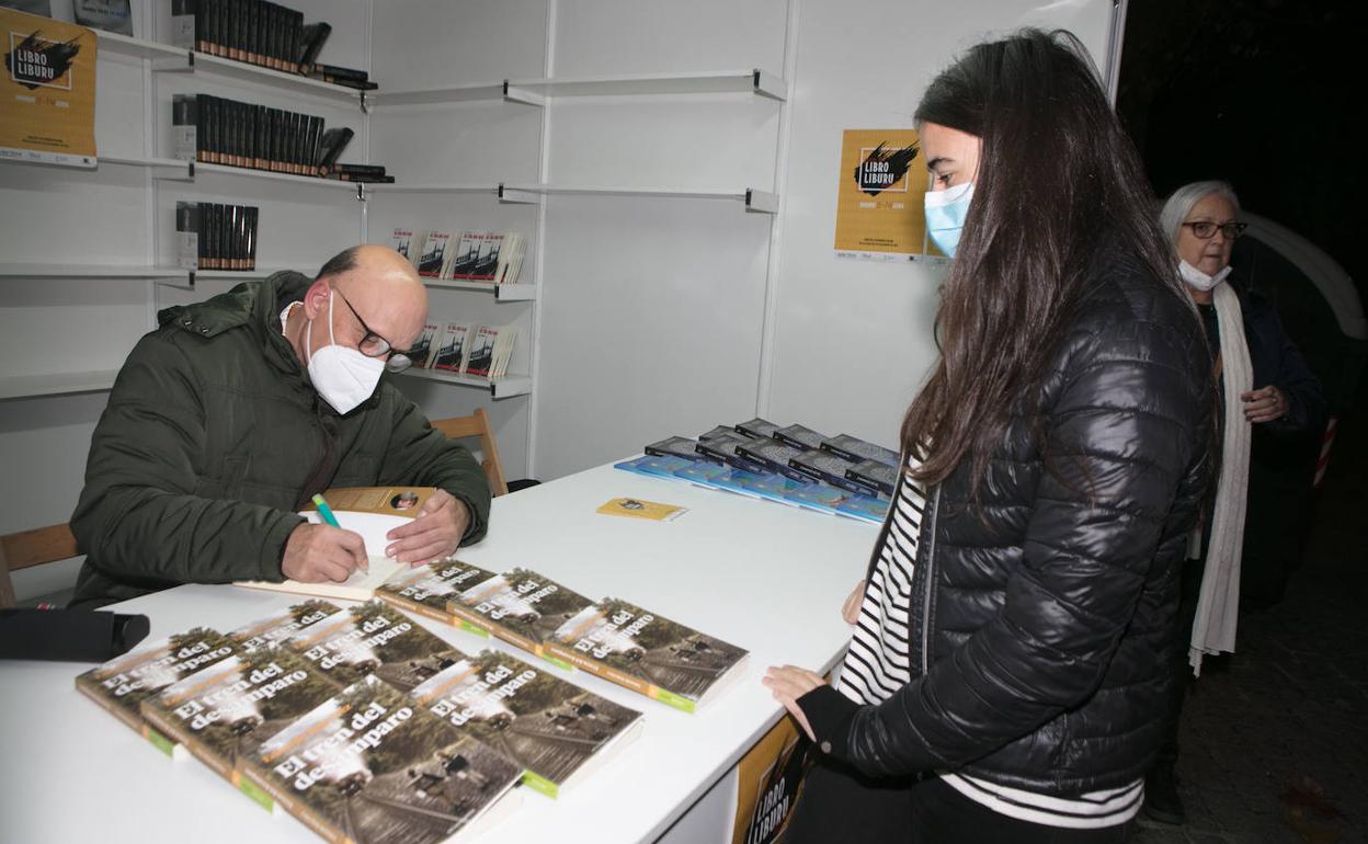 Eduardo Rojo firma ejemplares de 'El tren del desamparo' en la feria de la capital alavesa.