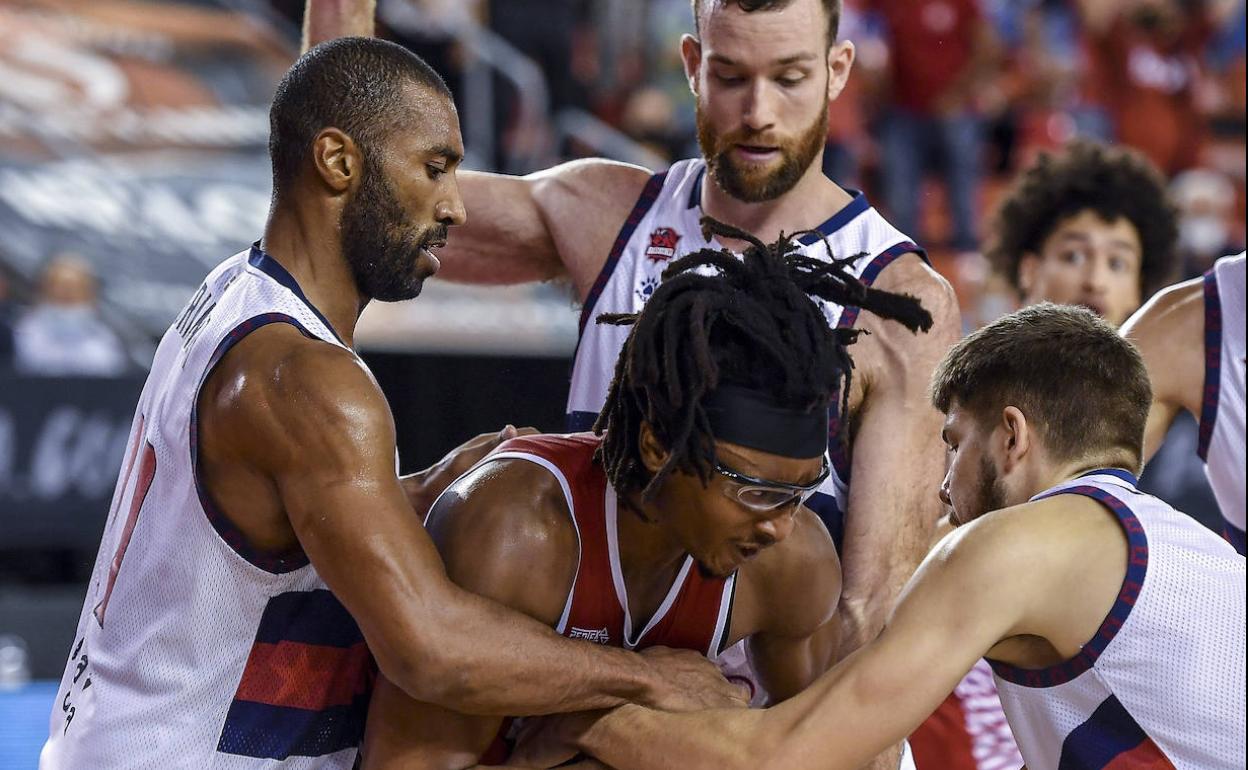 Moneke, mejor recuperador de la ACB (1,6), protege el balón ante Giedraitis, Granger y Costello.