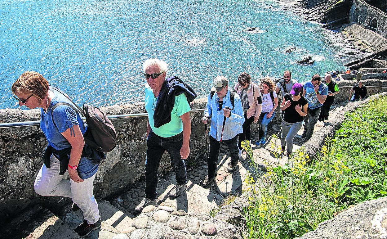 Un grupo de visitantes suben por las escaleras de la ermita nada más abrirse los accesos. 