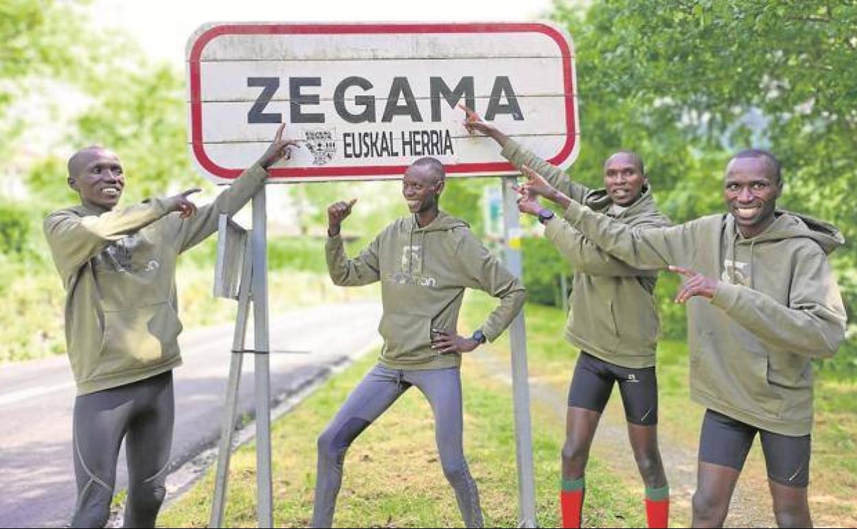Los cuatro atletas keniatas bromean ante la señal de entrada a Zegama. 