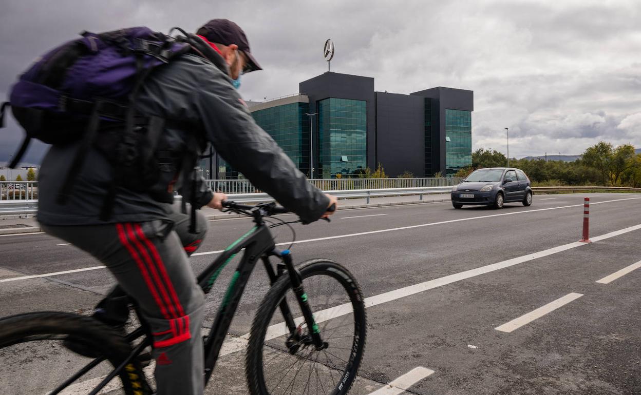 Un hombre se dirige en bici a un polígono industrial.