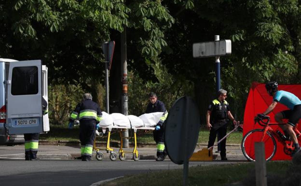 Operarios de la funeraria trasladan el cuerpo de la víctima. 