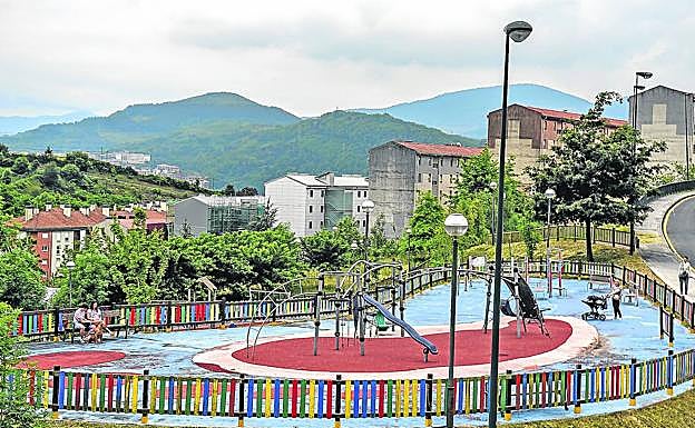 Parque infantil del barrio, rodeado de casas que acusan el paso del tiempo.