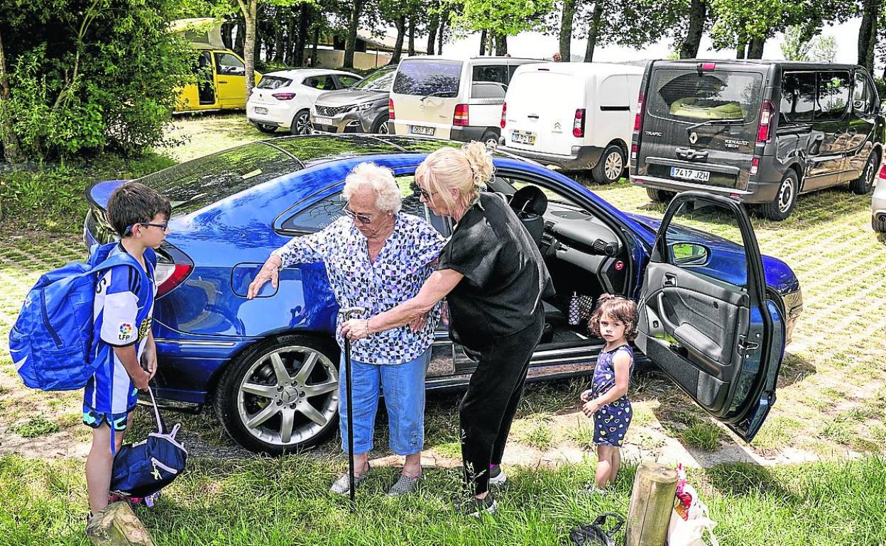 Mari Carmen Zarategi ayuda a su madre en el parking de Landa. 