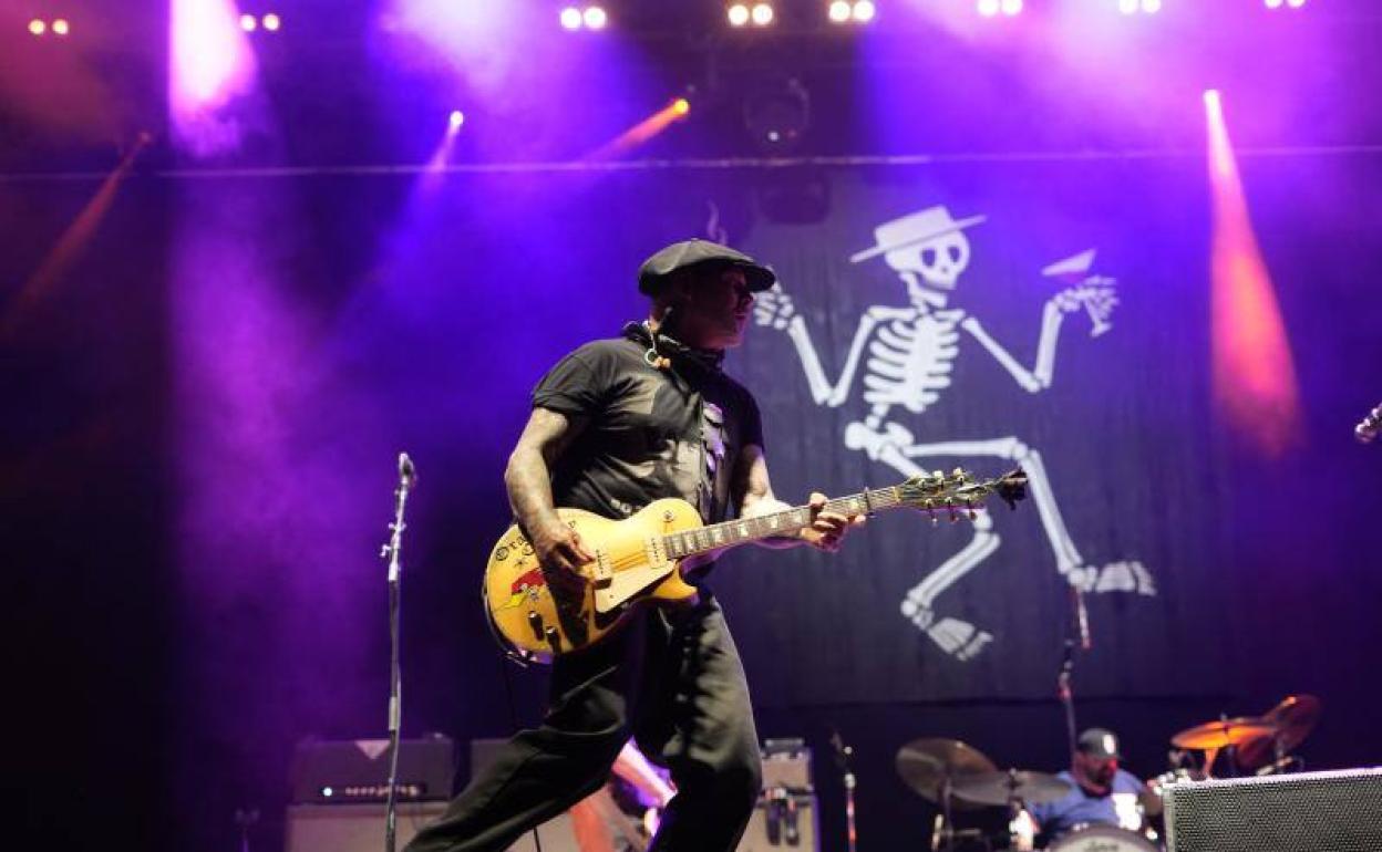 Mike Ness, en escena ante el esqueleto-logo de Social Distortion.