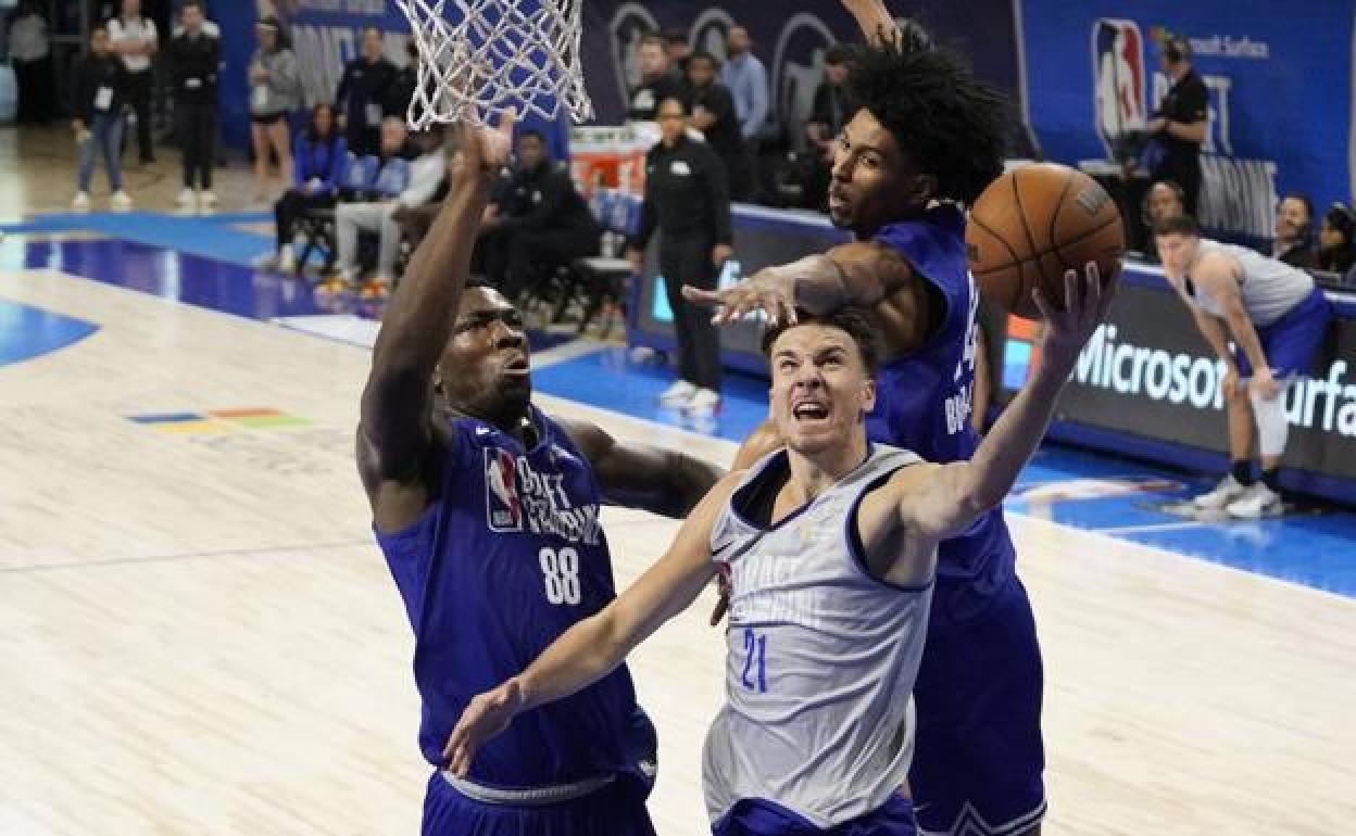 Hugo Besson intenta evitar el tapón de dos rivales durante las pruebas previas al Draft de la NBA.