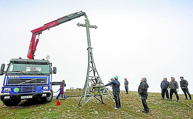 Un camión pluma eleva la cruz de unos 350 kilos para dejarla sobre la base, antes de comenzar los trabajos de soldadura. 