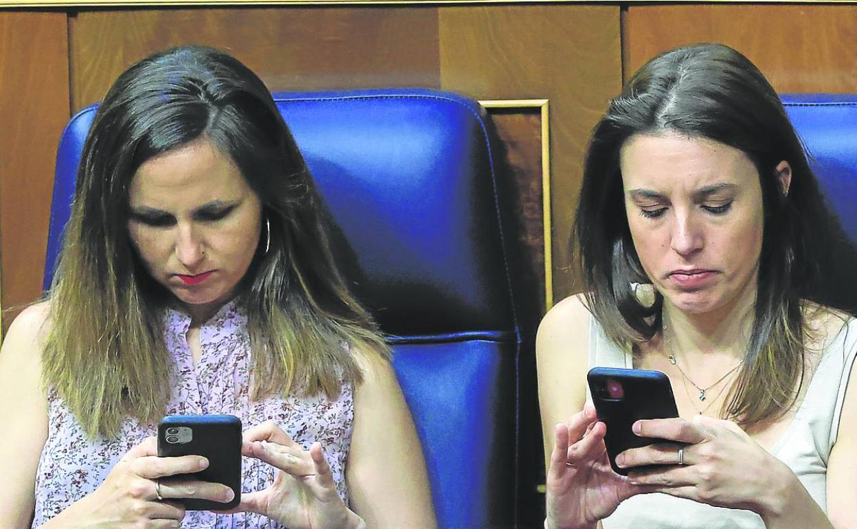 Las ministras Ione Belarra e Irene Montero, de Podemos, consultan los móviles desde sus escaños. 