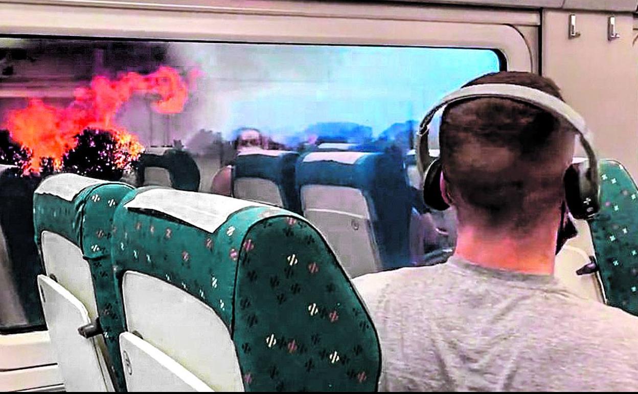 Un viajero observa las llamas desde el interior del AVE que viajaba hacia Ferrol. 