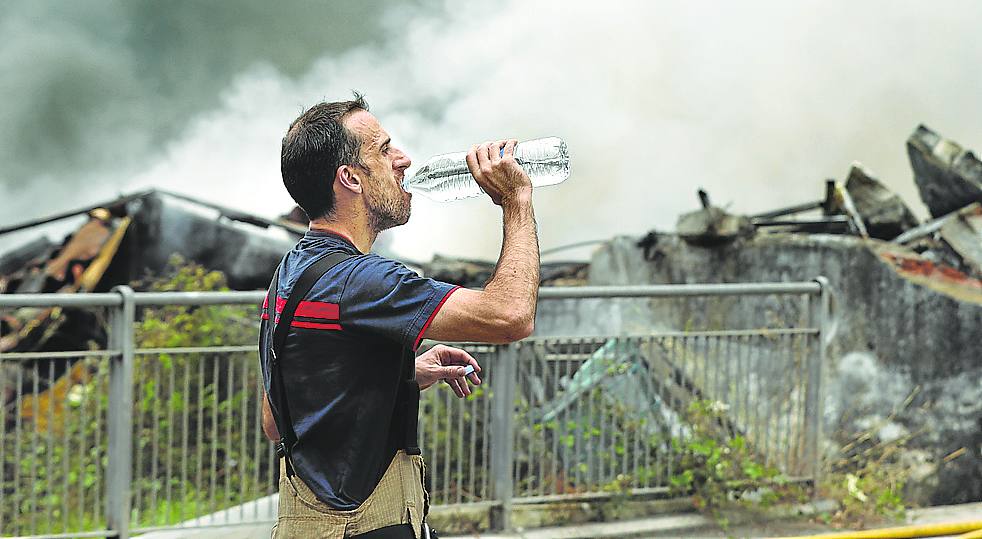 Un bombero bebe agua durante una pausa en las tareas de extinción del fuego. 