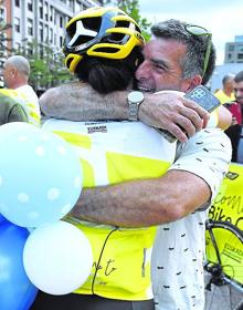 Imagen secundaria 2 - Juan María Aburto y Unai Rementeria posan con los ultrafondistas que trajeron el trofeo del Tour desde París en el Museo Guggenheim. Arriba, Ziortza Villa y Julián Sanz, con el testigo de la Grande Boucle en los últimos metros de su aventura a su llegada a Bilbao. A la derecha, la corredora se funde en un abrazo en la 'meta' de la villa.