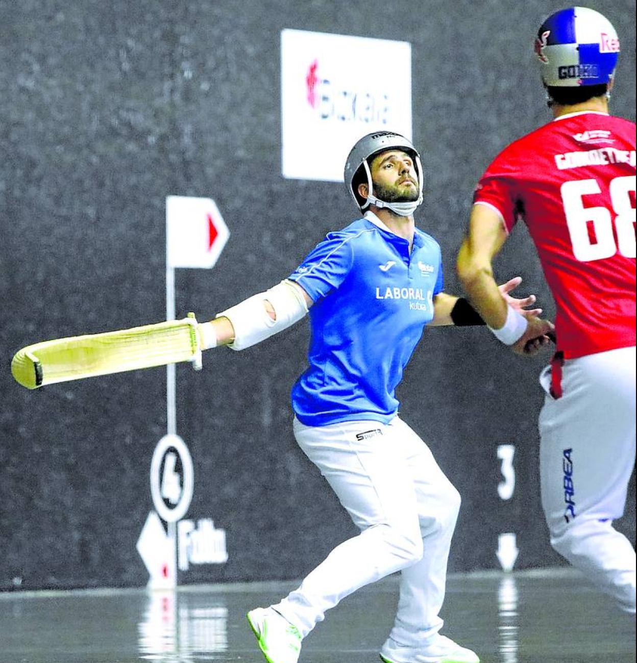 Olharan suelta la derecha ante la mirada de Goikoetxea en el frontón Jai Alai de Gernika. 