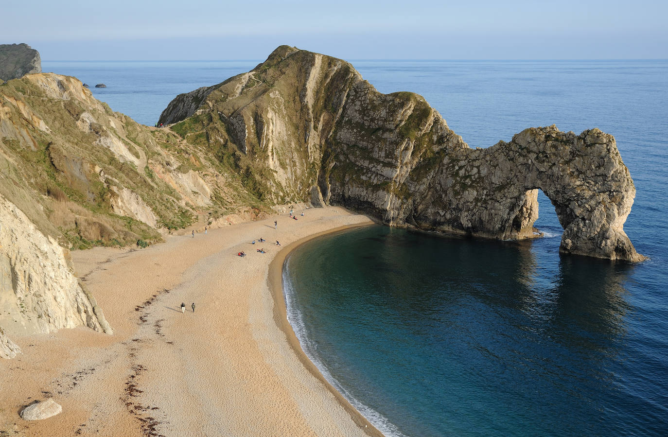 DURDLE DOOR (Inglaterra) | En el estado de Dorset, antiguamente conocido como Dorsetshire, ubicado al suroeste de Inglaterra y sobre el famoso Canal de la Mancha, se encuentra una extraña formación rocosa que se ha convertido en la más fotografiada de toda la Costa Jurásica debido a la perfección con la que parece haberse tallado. El arcose formó como resultado de la erosión que sufrieron las rocas más suaves por la marea constante.