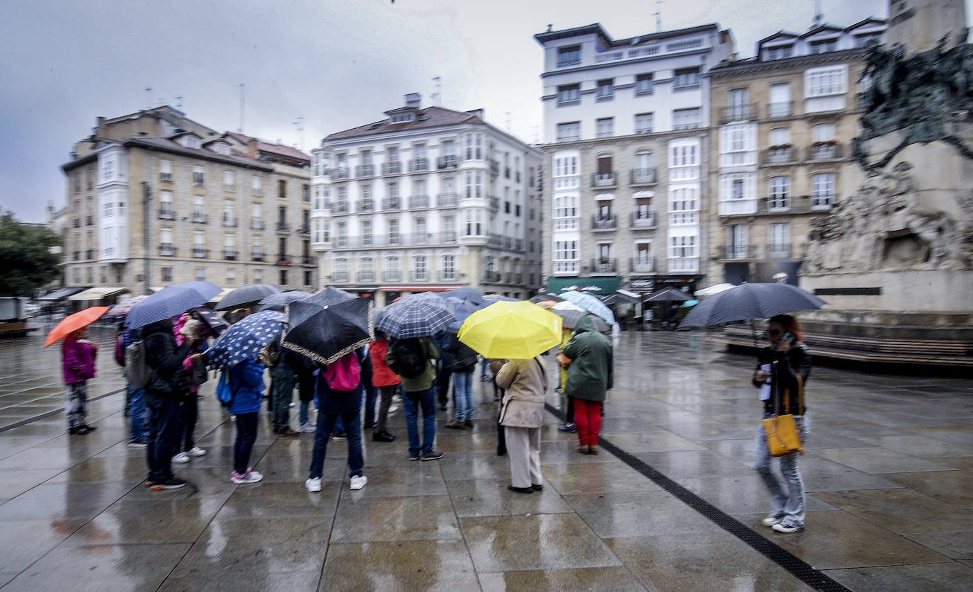 Un grupo de personas se protege de la lluvia en el centro de Vitoria.