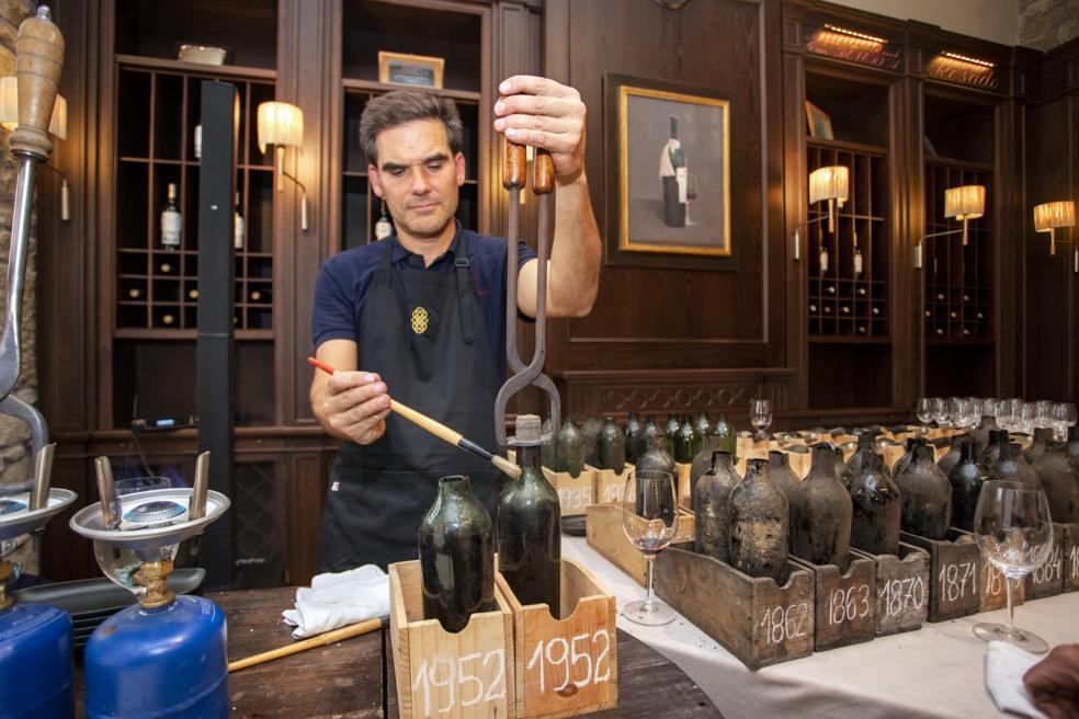 La apertura de las botellas, un ritual para cortar los cuellos con las tenazas al rojo vivo y evitar roturas de corchos de más de cien años. 