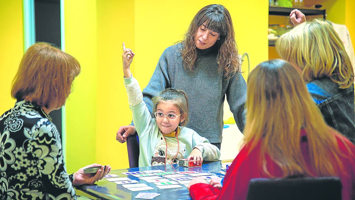 La pequeña Astrid, con altas capacidades, durante una sesión de apoyo junto a su madre Estíbaliz González (detrás) y la experta Elisa Álvarez (a la izquierda). 