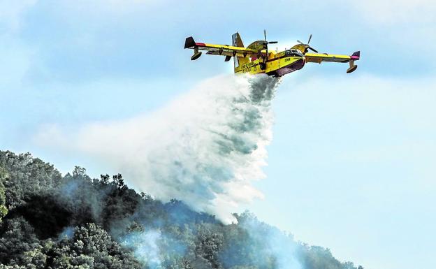 Un hidroavión descarga ayer agua sobre un sector en llamas de la zona de La Herrera, en Zalla. 