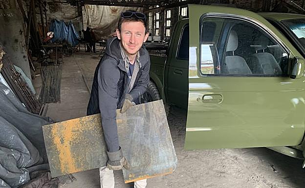 Imagen principal - Arriba, Iván Oleksii en el taller en el que blindan los todoterrenos. Voluntarios de la Legión Georgiana junto a uno de los coches. Una ametralladora pesada en uno de los 4x4.