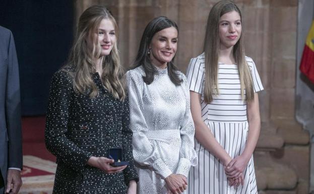 Imagen principal - Arriba. La princesa Leonor y la infanta Sofía, junto a su madre, doña Letizia. Debajo. Vista detallada de los zapatos (i-d) de la princesa Leonor, la reina Letizia, y la infanta Sofía.