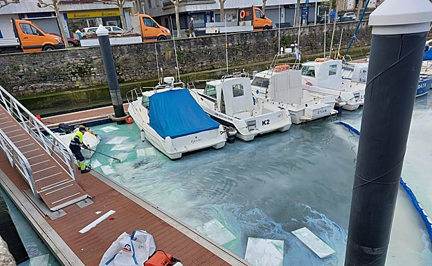 Varios operarios retiran parte del gasoil mediante paños. 