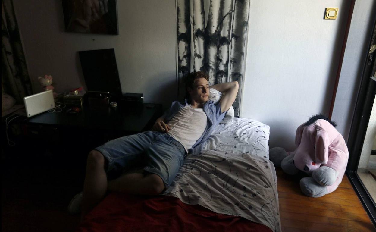 Un joven, en su habitación en casa de sus padres.