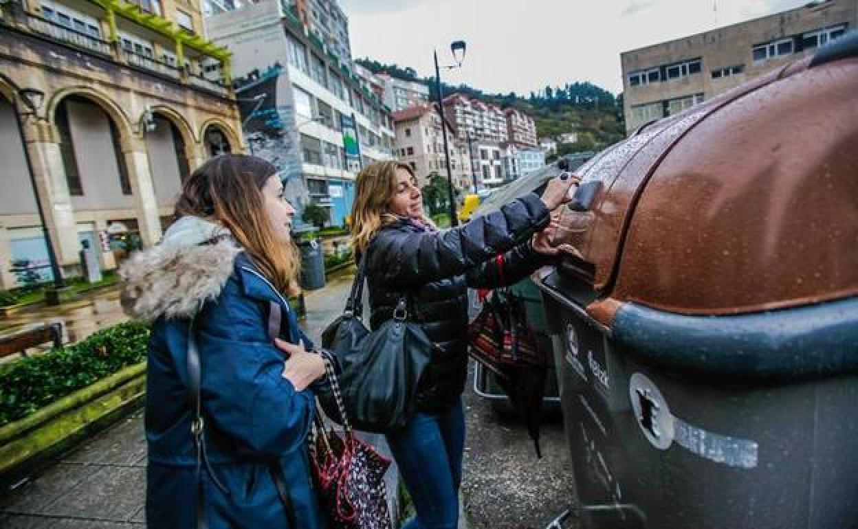 Una mujer de Ondarroa acerca la tarjeta electrónica para abrir el contenedor marrón. 