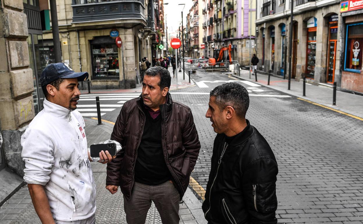 El empresario Moulay Driss, en el centro, conversa con dos compatriotas marroquíes en Bilbao. 