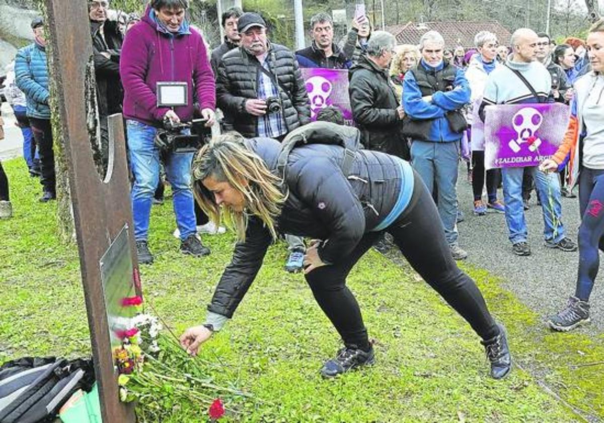 Los participantes en el homenaje de ayer realizan una ofrenda foral en la escultura colocada junto al vertedero en recuerdo de las dos víctimas del derrumbe