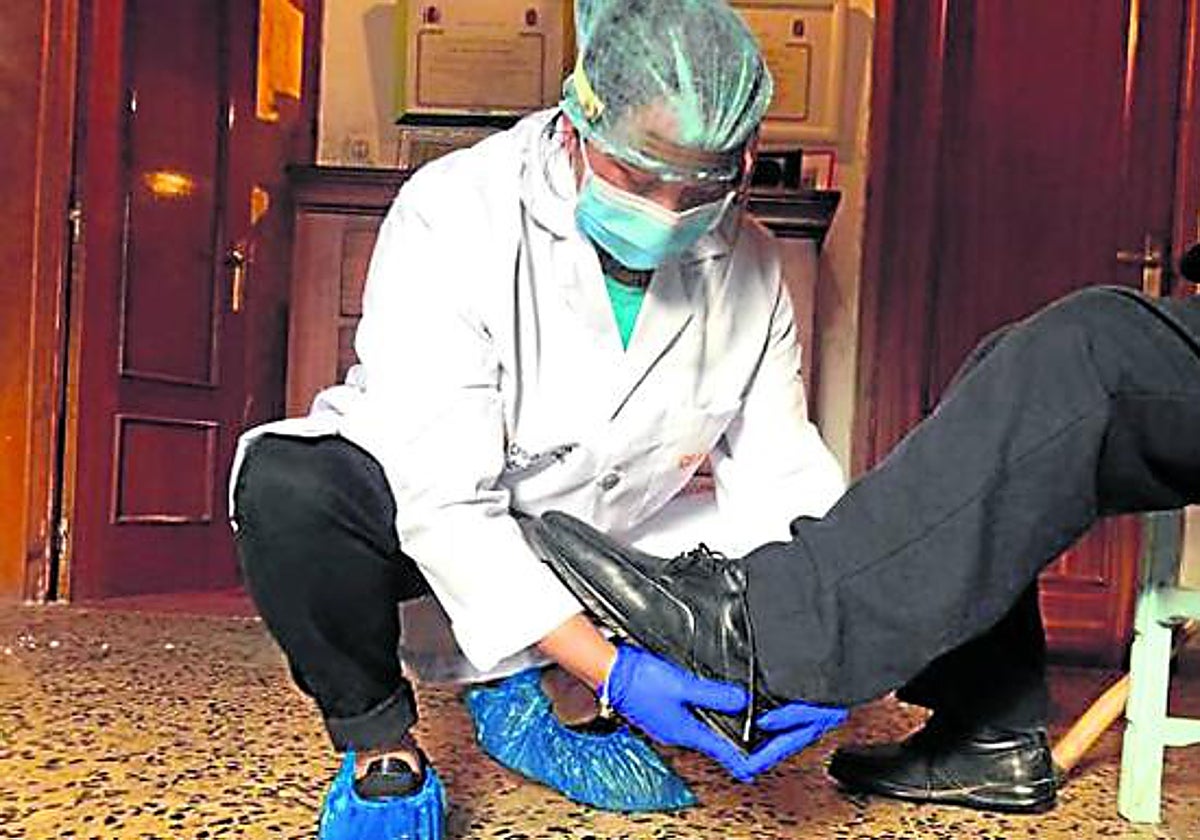 Una trabajadora ayuda a calzarse a un usuario.