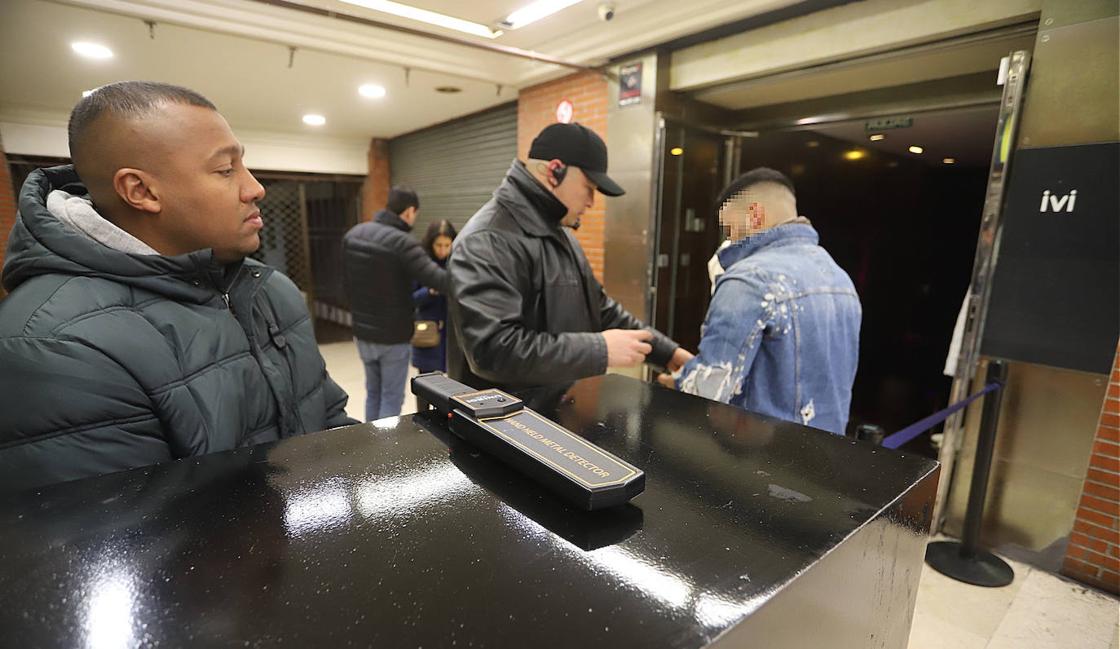 Dos de los vigilantes, con el detector de metales portátil en primer término.