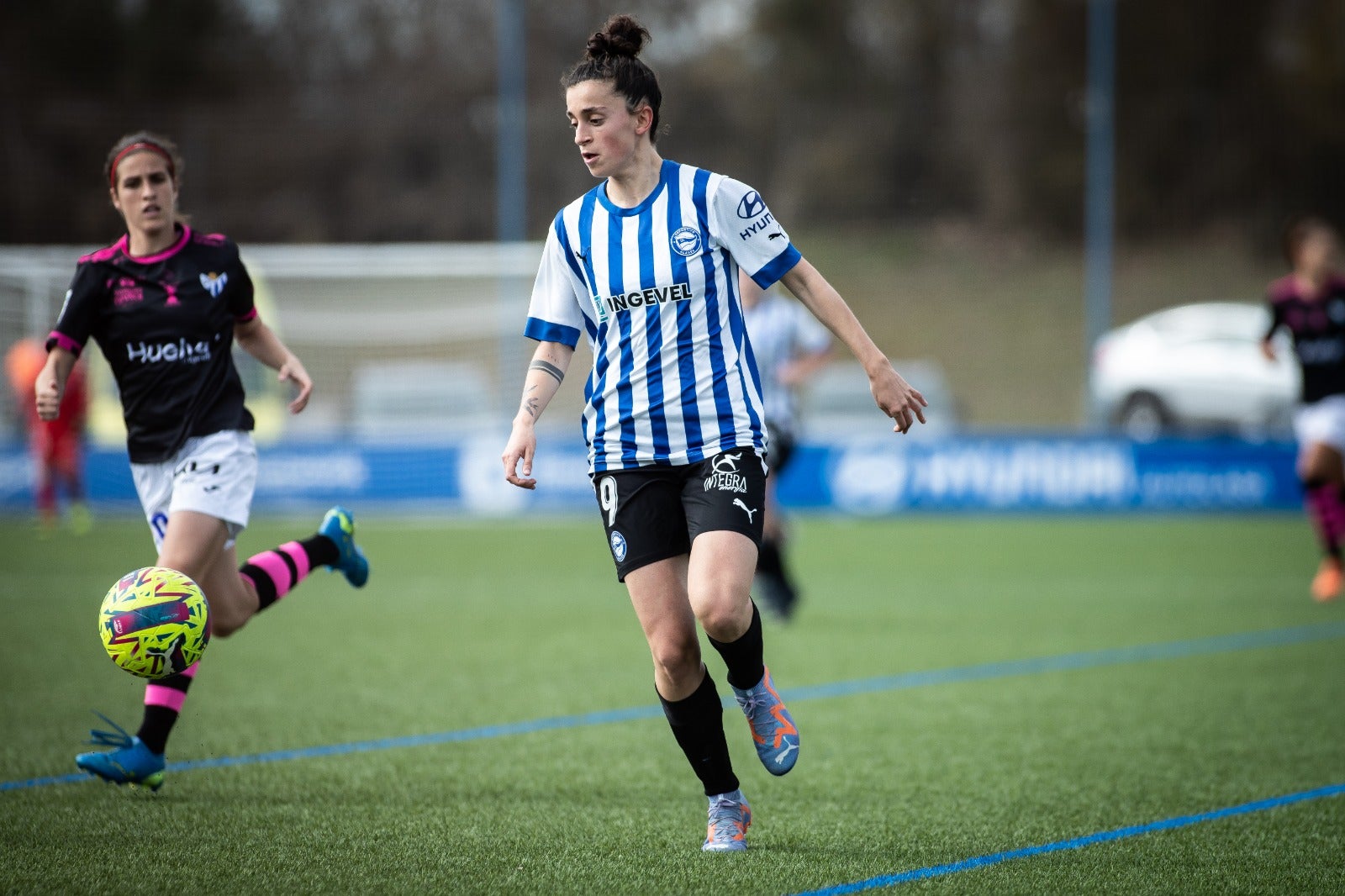 Sanadri controla el balón durante el encuentro, con Edgren como espectadora más cercana.