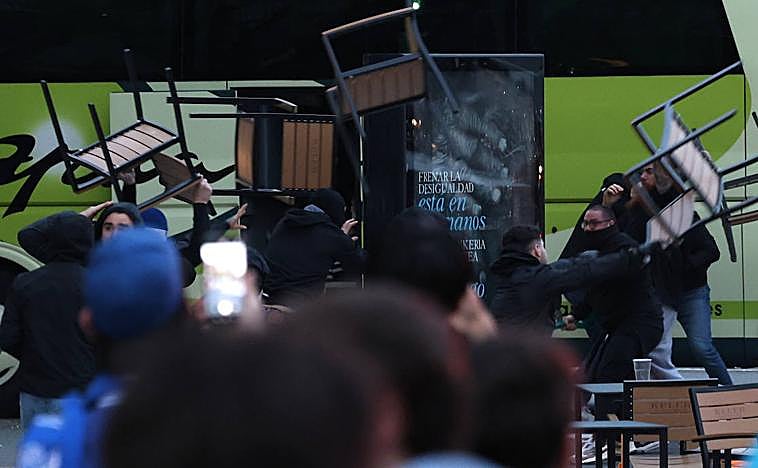 Imagen principal - Lanzamiento de sillas y botellas entre aficionados de La Roma y la Real Sociedad antes del partido