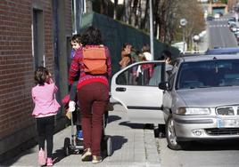 Una madre acompaña a su hijo a la escuela por una acera de la calle Zearreta.