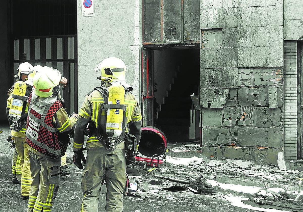 Los bomberos sofocan el incendio que provocó el pirómano de Sestao junto al inmueble que reside.