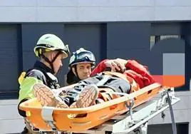 Los bomberos inmovilizan en una camilla a uno de los heridos para proceder a su traslado.