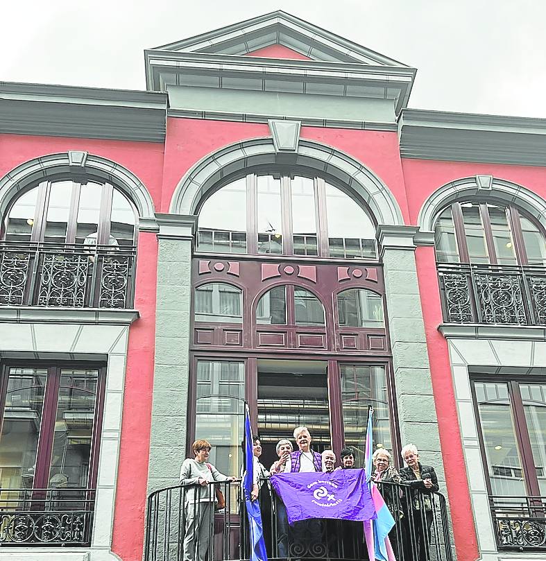 Imagen - Fiesta. Eibarreses despliegan banderas en la balconada de la Casa de la Mujer.