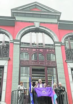 Imagen - Fiesta. Eibarreses despliegan banderas en la balconada de la Casa de la Mujer.